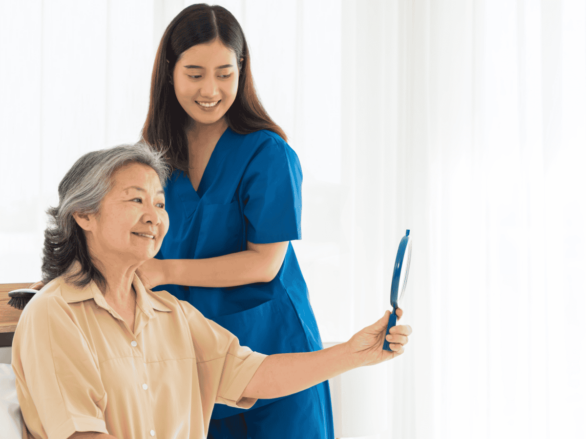 Caregiver helping an older woman with grooming as part of personal care at home