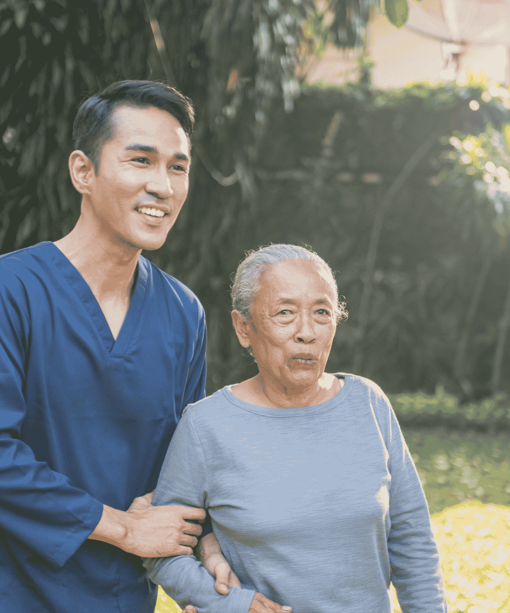 Caregiver helping an older woman stand and walk safely at home in Spring Hill, TN