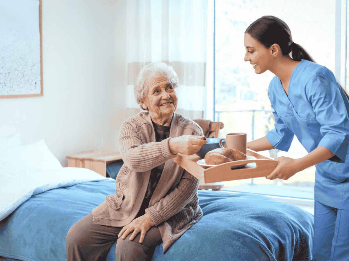 Caregiver helping a senior with a meal during daytime dementia care at home