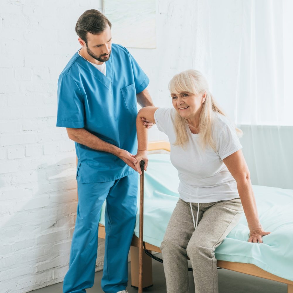 Caregiver helping a senior woman with a walking stick
